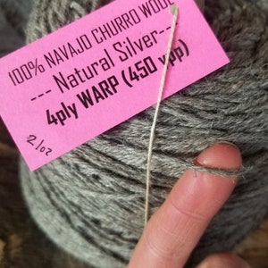 May include: A skein of gray 100% Navajo Churro wool yarn labeled "Natural Silver" with a 4-ply warp and 450 yards per pound.