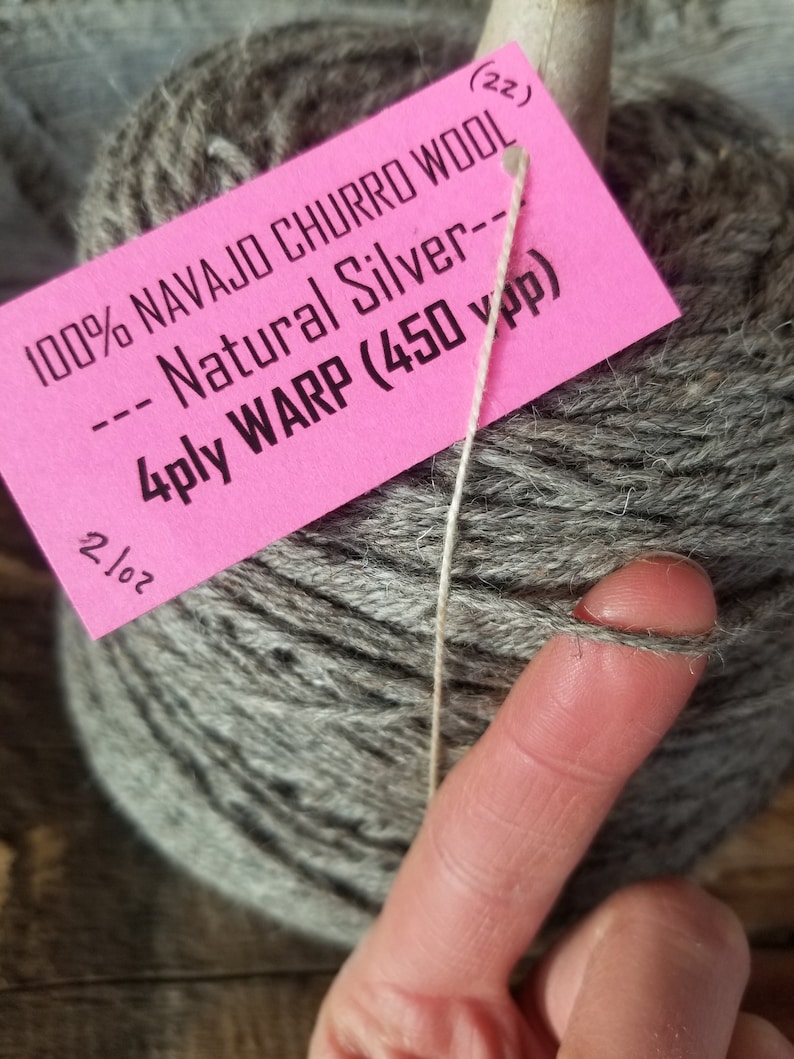 May include: A skein of gray 100% Navajo Churro wool yarn labeled "Natural Silver" with a 4-ply warp and 450 yards per pound.