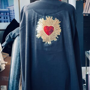 Black cape coat with gold and red hearts. Size 5 X large but fits sizes UK 10 to 14