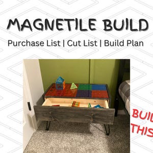May include: A wooden table with a drawer and hairpin legs. The table top is covered in colorful magnetic tiles. The table is in a room with a green wall and a white door.