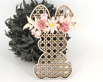 May include: A wooden bunny shaped ornament with a woven pattern and a pink and white flower crown.