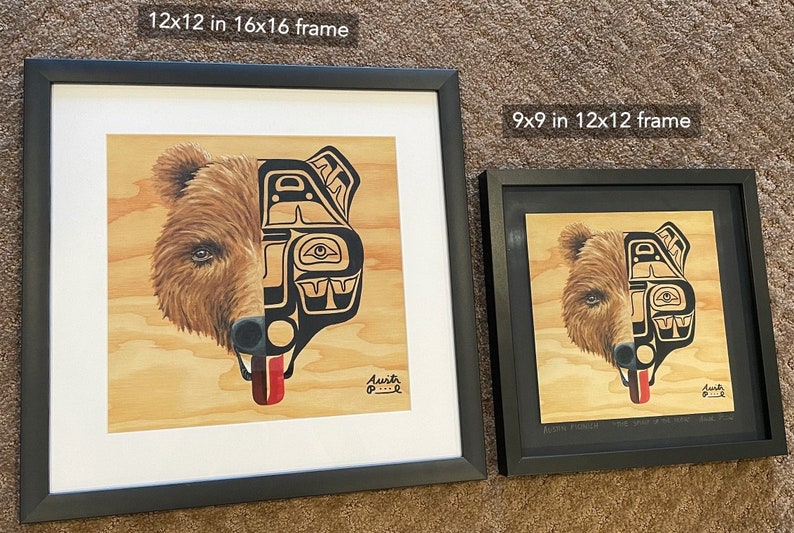 K&ouml;nnte beinhalten: Zwei gerahmte Drucke eines B&auml;ren mit einem indianischen Design auf der einen H&auml;lfte seines Gesichts. Der kleinere Druck ist 9x9 Zoll in einem 12x12 Zoll Rahmen. Der gr&ouml;&szlig;ere Druck ist 12x12 Zoll in einem 16x16 Zoll Rahmen. Beide Drucke sind auf einem Holzgrund und tragen die Unterschrift des K&uuml;nstlers unten rechts.