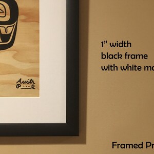 K&ouml;nnte beinhalten: Gerahmter Druck eines stilisierten Schwarzwei&szlig;bildes auf Holzgrund. Der Druck ist mit einem 2,5 cm breiten schwarzen Rahmen und einem wei&szlig;en Passepartout gerahmt. Der Text "Framed Print" ist unterhalb des Bildes sichtbar.