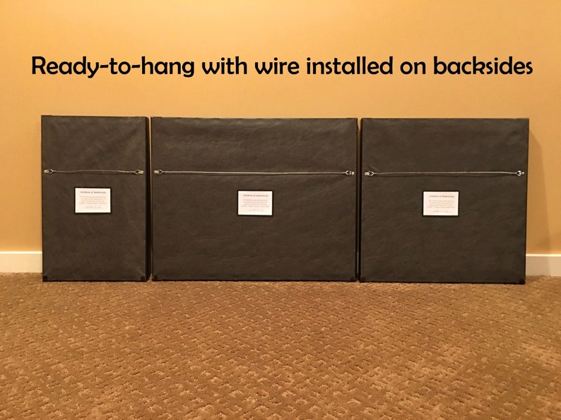 May include: Three framed prints with black frames and brown mats. The backs of the frames are visible, showing a wire hanger attached to each frame. The text "Ready-to-hang with wire installed on backsides" is visible at the top of the image.