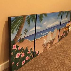 May include: A three-panel canvas painting depicting a tropical beach scene. The left panel features palm trees and pink flowers, the middle panel shows a sandy beach with two white chairs facing the ocean, and the right panel shows a palm tree with a sign that reads "Bar Beach".