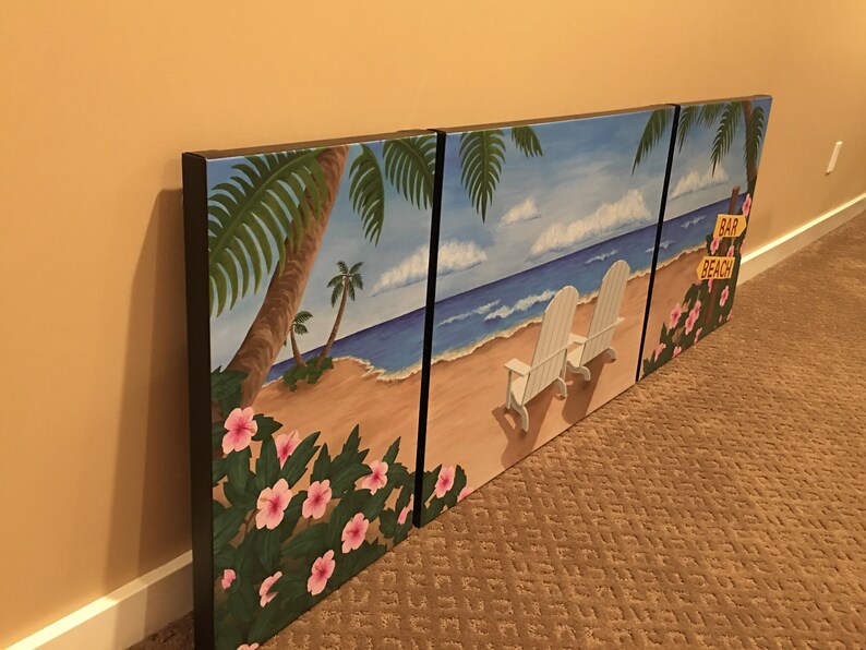 May include: A three-panel canvas painting depicting a tropical beach scene. The left panel features palm trees and pink flowers, the middle panel shows a sandy beach with two white chairs facing the ocean, and the right panel shows a palm tree with a sign that reads "Bar Beach".