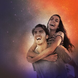以下が含まれることがあります： カラフルな星空を背景に、笑い合うカップル。女性は男性を背負っており、2人とも上を見上げています。