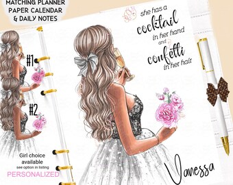 May include: A white planner with a gold ring binding. The cover features a hand-drawn illustration of a woman in a sparkly dress holding a glass of champagne. The text "she has a cocktail in her hand and confetti in her hair" is written above the woman. The text "Vanessa" is written in cursive at the bottom of the page. The text "Watermarks will be removed :)M" is written at the bottom of the page.