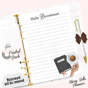 Op de afbeelding: Een witte planner met gouden ringen en een gelinieerde pagina. De pagina heeft bovenaan de tekst "Daily Devotional" en onderaan een zwarte Bijbel met een roze lint, een kopje koffie en een pen met een bruine strik. Rechtsonder staat de tekst "Missy Bello Planners".