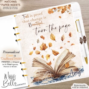 May include: A planner dashboard insert featuring an open book with floating autumn leaves and the text Fall is proof that change is Beautiful.. turn the page. The design includes the name Amy in dark blue script and a white pen in a holder.
