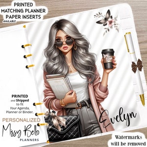 Puede incluir: Una cubierta de agenda blanca con una ilustración colorida de una mujer con cabello gris que lleva gafas de sol, una chaqueta rosa y una camisa blanca. Ella sostiene una pila de libros y una taza de café que dice "Boss Babe". El texto "Evelyn" está escrito en cursiva negra en la esquina inferior derecha de la cubierta.