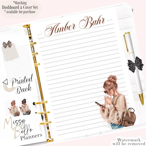 Op de afbeelding: Witte planner met gouden accenten, gelinieerde pagina's en een pen met een zwarte strik. De planner heeft een illustratie van een vrouw met een telefoon en koffie. Tekst bevat "Amber Bahr" en "Missy Bello Planners."