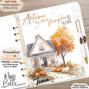 Puede incluir: Una hoja de inserción personalizada para agenda con una ilustración en acuarela de una casa blanca con puerta oscura, un gran árbol de otoño naranja y calabazas en el porche. El texto dice Autumn LEAVES & pumpkins PLEASE y el nombre Tonia.