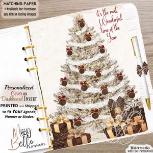 May include: A planner dashboard insert featuring a white Christmas tree decorated with brown ornaments and red bows. The text reads, it's the most wonderful time of the year. Below the tree are brown gift boxes with gold ribbons and bows.