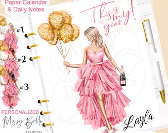 May include: A personalized planner with a pink dress illustration holding gold balloons and a champagne bottle. The planner includes the text "This is my year!" and "Layla". The planner also includes a matching paper calendar and daily notes.