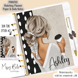May include: A white planner with a black and white polka dot pattern. The planner features a drawing of a woman with blonde hair holding a coffee cup. The text "Ashley" is written in black on the planner. The text "Watermarks will be removed :)M" is written in black at the bottom of the planner.