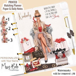 May include: A planner with a fashion illustration of a woman holding red shoes, surrounded by shopping bags and shoes. The planner includes the text "Kimberly" and "When I'm tired of shopping, I sit down and try on shoes."