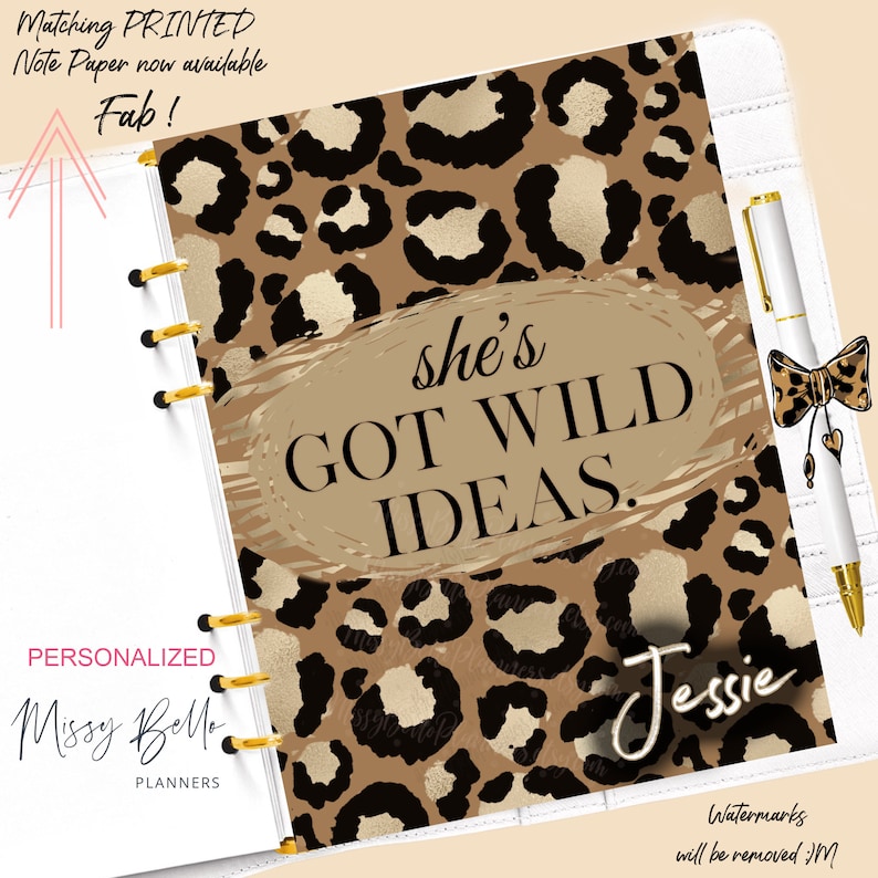 Puede incluir: Una agenda personalizada con una cubierta de estampado de leopardo. La cubierta tiene el texto "she's GOT WILD IDEAS." y el nombre "Jessie" escrito en cursiva. La agenda es blanca con anillos dorados.