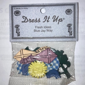 May include: A package of decorative buttons with various shapes, including kites, a sun, and a tree. The package reads "Dress It Up" and "Fresh Ideas Blue Jay Way". The buttons are in shades of pink, yellow, blue, and green.