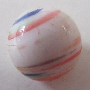 May include: A white glass marble with colorful stripes of red, blue, green, and brown. The marble is a sphere and has a glossy finish. This vintage toy is a classic game piece.