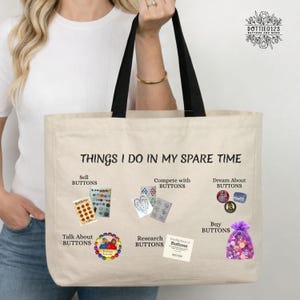 May include: Cream-colored tote bag with black handles, featuring the text "THINGS I DO IN MY SPARE TIME." The bag displays various activities related to buttons, including "Sell Buttons," "Compete with Buttons," and "Buy Buttons." The bag is held by a person.