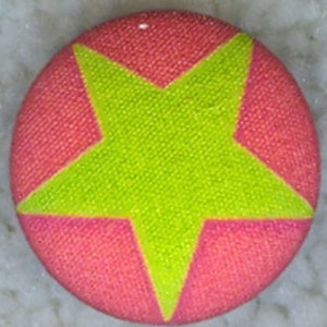 May include: A pink button with a bright green five-pointed star in the center.