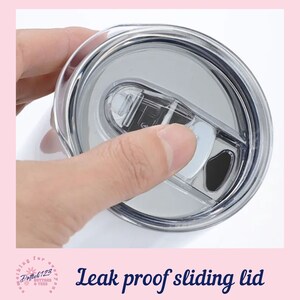 May include: Close-up of a clear plastic lid with a sliding mechanism. The lid is designed to be leak-proof and is likely for a tumbler or travel mug.