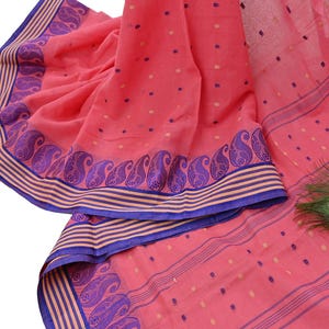 May include: A coral pink fabric featuring a repeating pattern of small dark blue and light gold dots. The border displays a prominent dark blue paisley design accented by horizontal stripes in alternating shades of coral and dark blue.