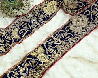 May include: Navy blue ribbon with gold floral embroidery and a red border. The ribbon features detailed patterns and embellishments, ideal for craft projects and decorative purposes. The ribbon's width is approximately 5 cm.