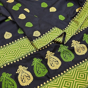 May include: A dark navy blue fabric featuring a repeating pattern of gold and lime green paisley motifs. The textile includes a wide border decorated with a geometric diamond design in alternating lime green and gold thread embroidery.
