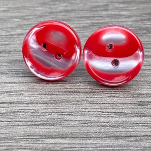 May include: Two red and white swirl buttons with two holes each.