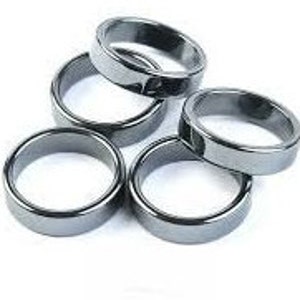 May include: Five smooth, black hematite rings. The rings are all the same size and are stacked on top of each other.