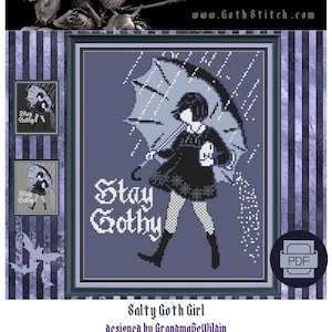 May include: Cross stitch pattern featuring a girl in a black dress and black boots holding an umbrella. The girl is standing in the rain and the text "Stay Gothy" is written in white letters. The pattern is framed in a black frame with a white border. The pattern is labeled "Salty Goth Girl" and "designed by GrandmabeWilain".