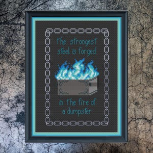 Puede incluir: Arte de punto de cruz enmarcado con un marco negro y un borde turquesa. La obra de arte presenta el texto "The strongest steel is forged in the fire of a dumpster" en turquesa, con un contenedor pixelado y llamas azules.