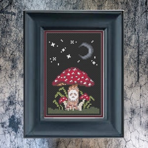 May include: A cross-stitch embroidery depicting a red and white mushroom with a skull inside, surrounded by smaller mushrooms and a crescent moon in a starry night sky.