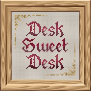 May include: Cross-stitch embroidery in a wooden frame with a red gradient design that reads "Desk Sweet Desk".