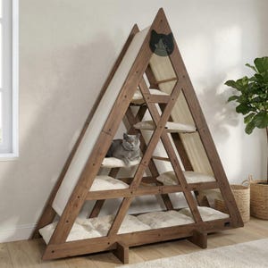 May include: A-frame cat tree with multiple levels. The wooden structure features a light-colored canvas and plush cushions. A gray cat is resting on one of the levels. The cat tree has the text "WLO" on the top.