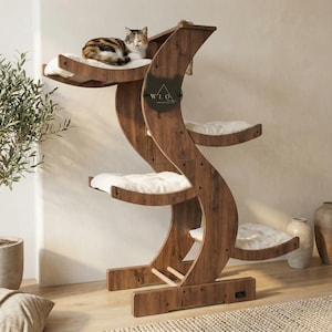 May include: A multi-level cat tree made of dark wood, featuring curved supports and multiple platforms with white cushions. A cat rests on the top level. The cat tree has a decorative plaque with the text "W.L.O."
