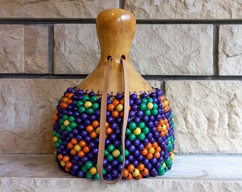 タカラガイの殻でできたひょうたんのシェケレ：白いビーズで飾られた