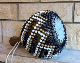 タカラガイの殻でできたひょうたんのシェケレ：白いビーズで飾られた