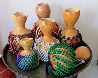 タカラガイの殻でできたひょうたんのシェケレ：白いビーズで飾られた