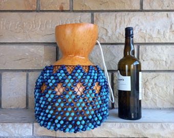 タカラガイの殻でできたひょうたんのシェケレ：白いビーズで飾られた