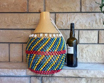 タカラガイの殻でできたひょうたんのシェケレ：白いビーズで飾られた