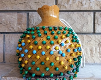 タカラガイの殻でできたひょうたんのシェケレ：白いビーズで飾られた