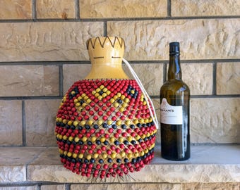 タカラガイの殻でできたひょうたんのシェケレ：白いビーズで飾られた