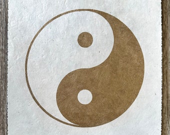 Könnte beinhalten: Ein braunes und weißes Yin-Yang-Symbol auf weißem Papierhintergrund.