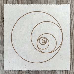 Op de afbeelding: Een wit vel papier met een bruin spiraalontwerp. De spiraal bestaat uit concentrische cirkels, met de kleinste cirkel in het midden.