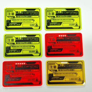 May include: Six yellow and red plastic cards with black text. The cards have the text "Certified" and "注意" which is Japanese for "Attention". The cards have numbers on them ranging from 5,000 to 1,000,000.