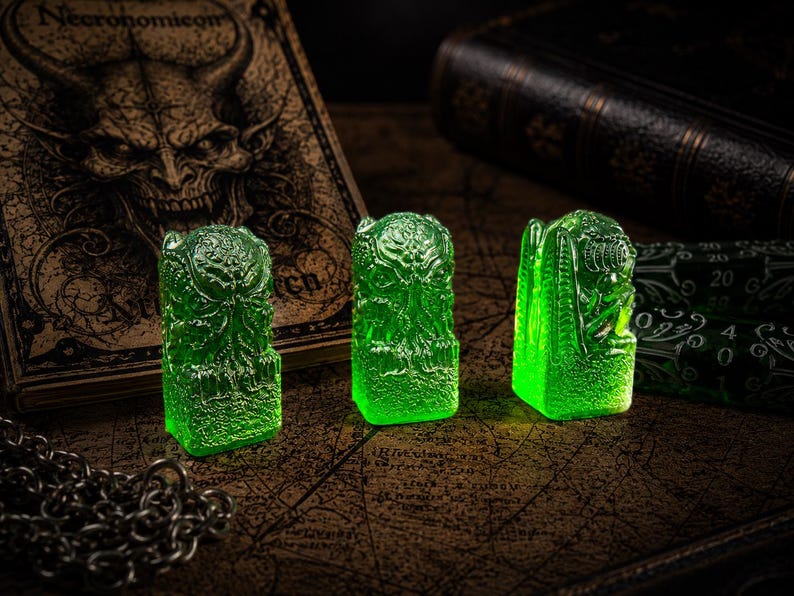 May include: Three translucent, vibrant green resin figurines, each featuring a detailed, tentacled creature design. These small, upright sculptures have a textured base and a smooth, glossy finish, showcasing intricate carvings of a mythical entity.