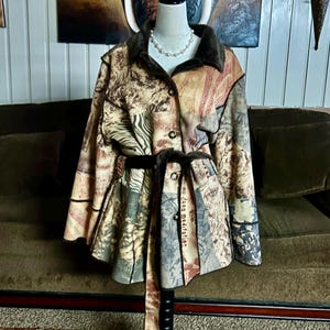 May include: A multi-colored patchwork jacket with a brown faux fur collar, a black belt, and a button closure. The jacket has a variety of patterns, including animal prints, stripes, and floral designs.